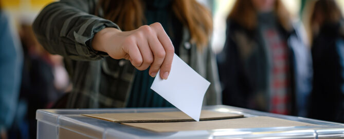 Eine Frau wirft ihren Wahlzettel in eine Wahlurne.