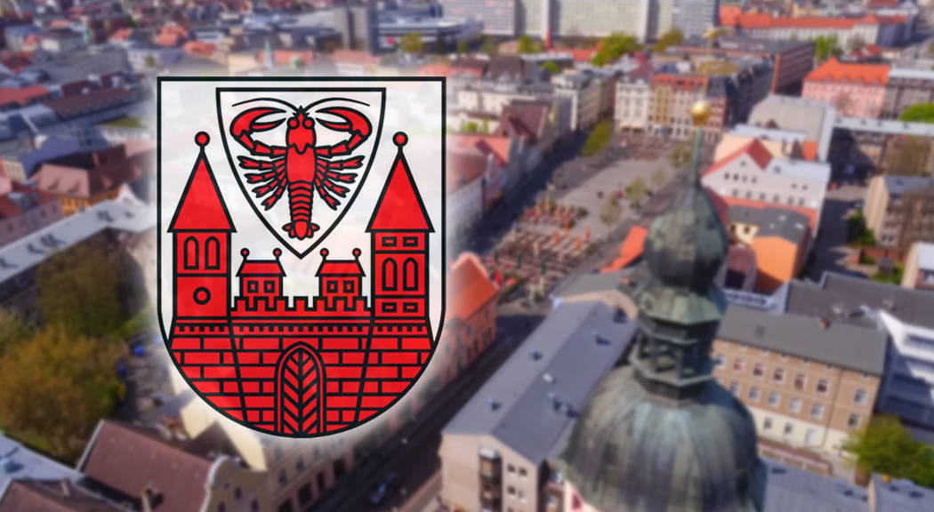 Das Foto zeigt die Cottbuser Innenstadt von oben und das Wappen der Stadt Cottbus.