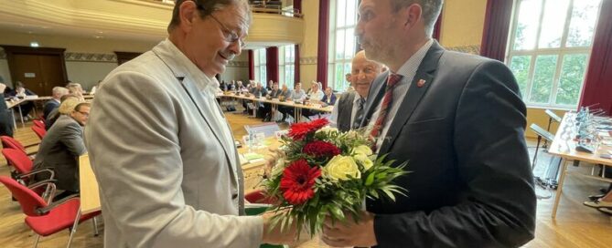 Dr. Wolfgang Bialas bekommt von Cottbus Oberbürgermeister Tobias Schick einen Blumenstrauß überreicht