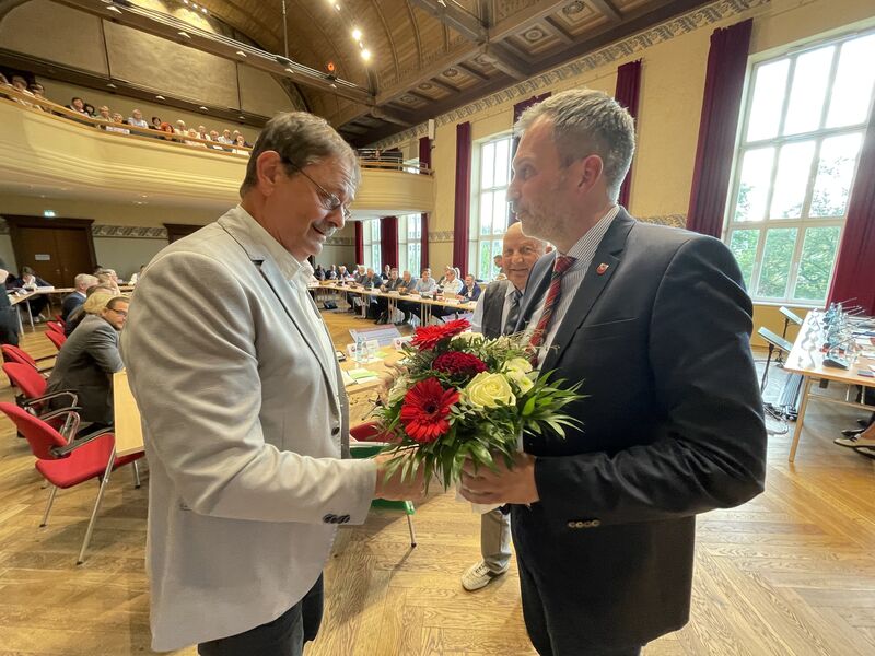 Dr. Wolfgang Bialas bekommt von Cottbus Oberbürgermeister Tobias Schick einen Blumenstrauß überreicht