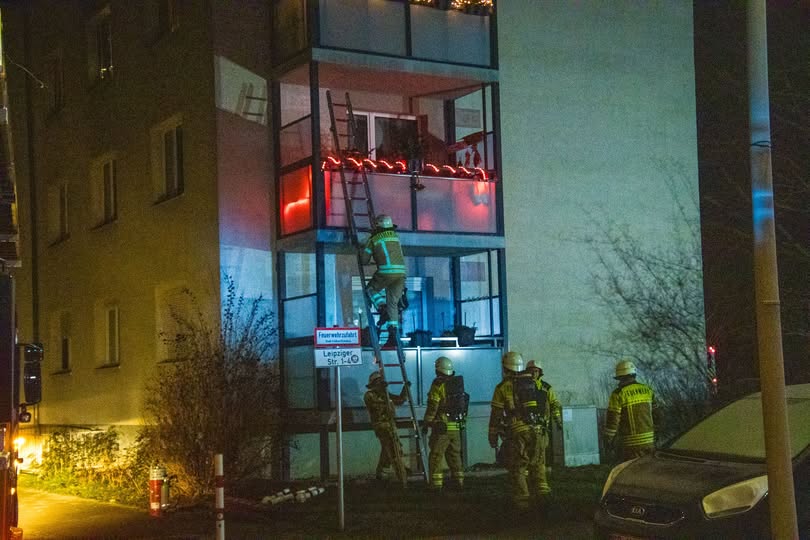 Feuerwehrleute klettern auf einen Balkon