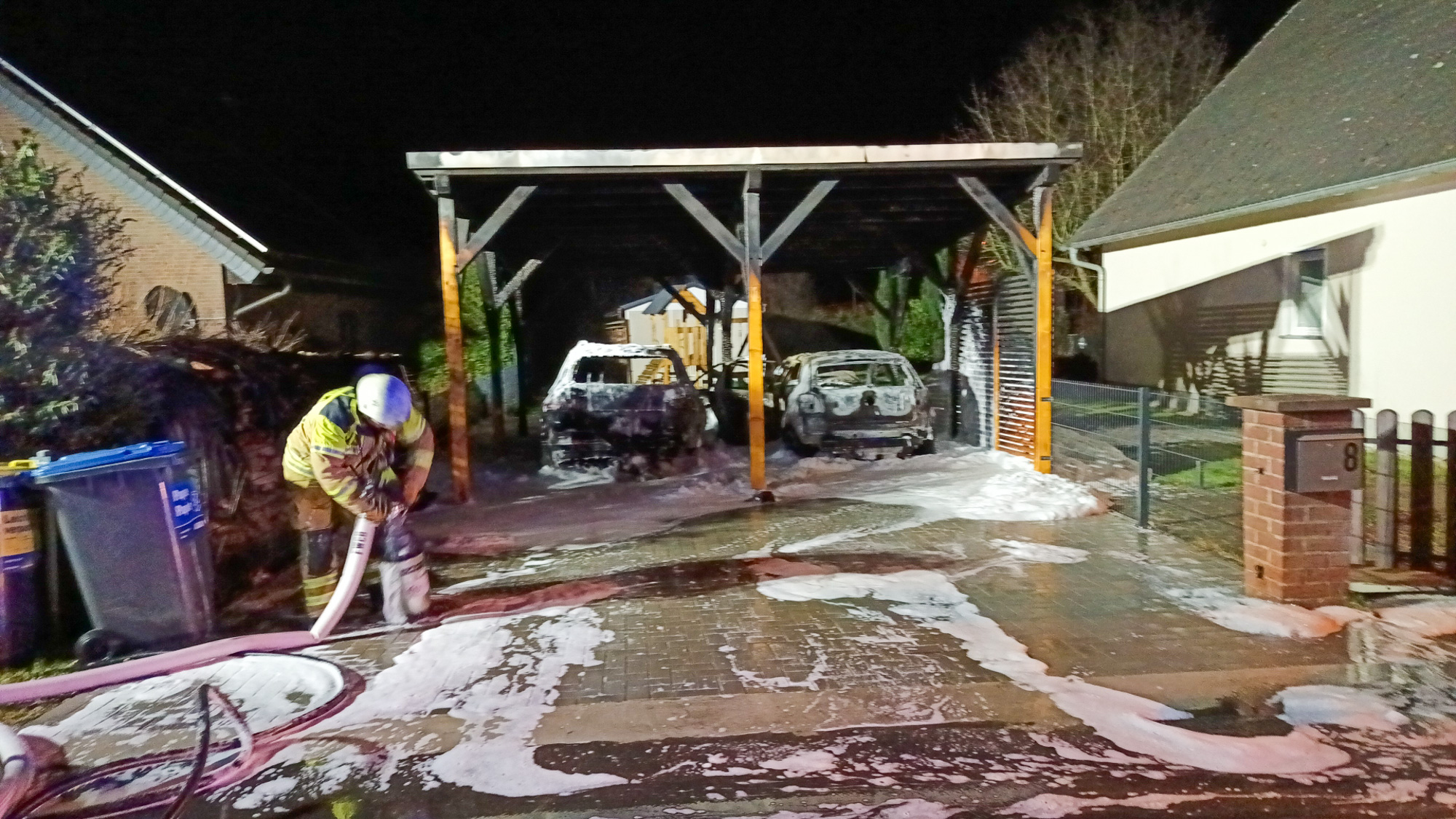 Zwei Autos stehen abgebrannt unter ein Carport